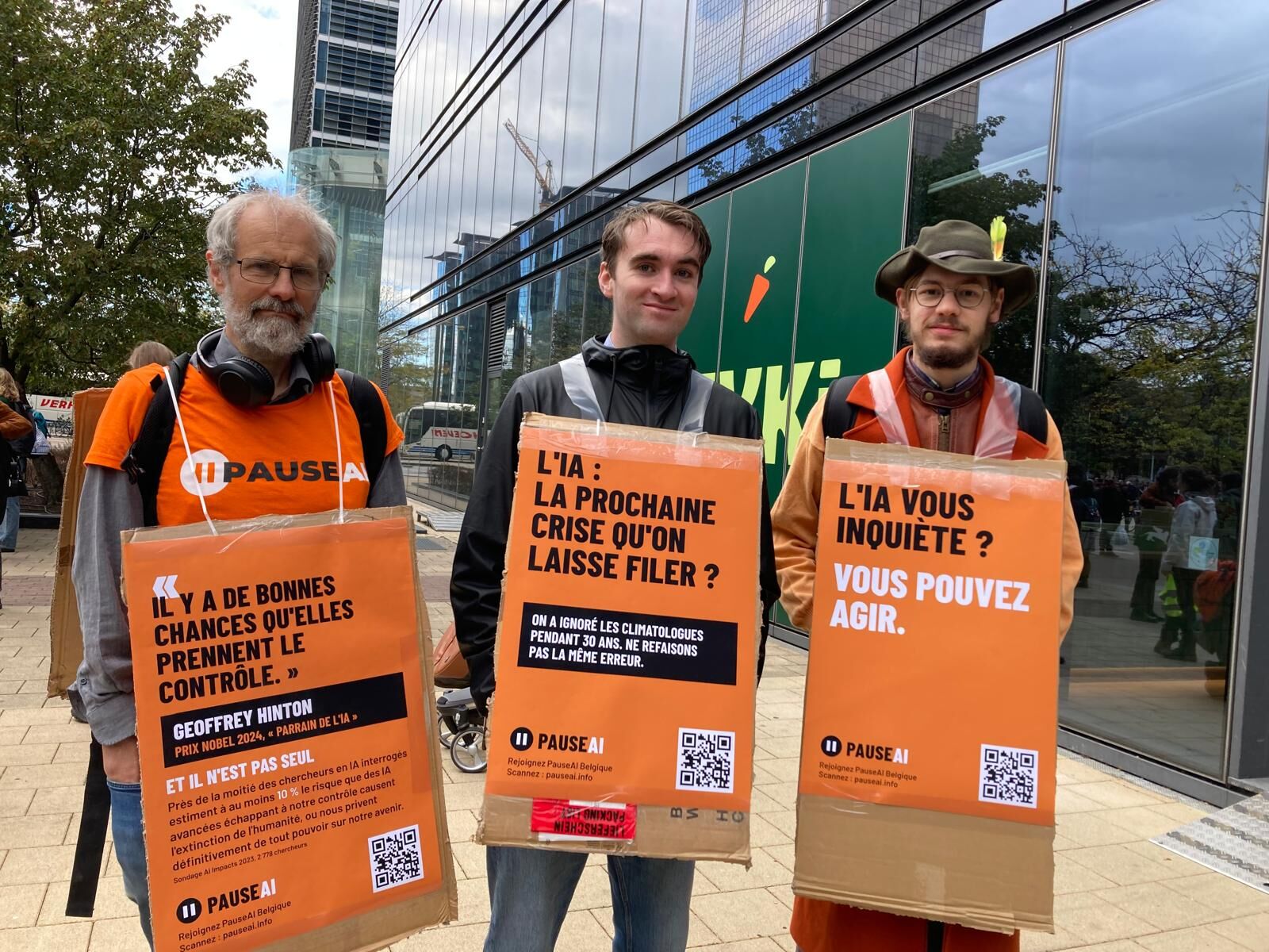 Trois bénévoles portant des pancartes PauseAI en français lors de la marche pour le climat.